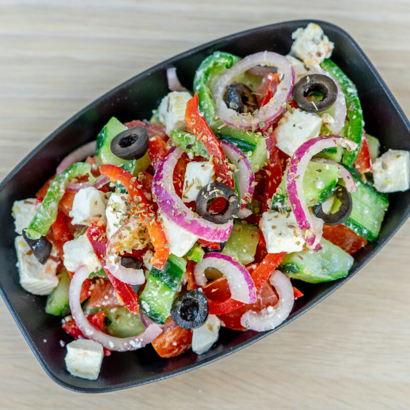 Salade grecque : Poivrons, tomates, concombres, oignons, olives noires, feta, huile d'olive.